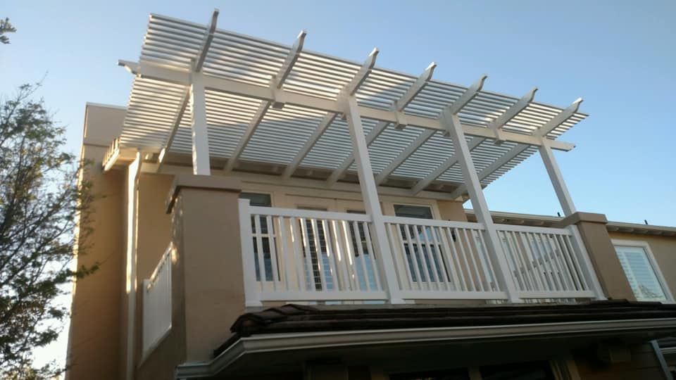 A house with a balcony and a pergola on top of it