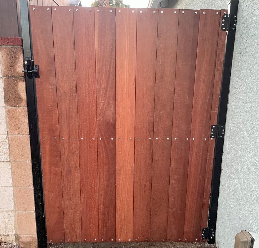 A wooden gate with a black metal frame