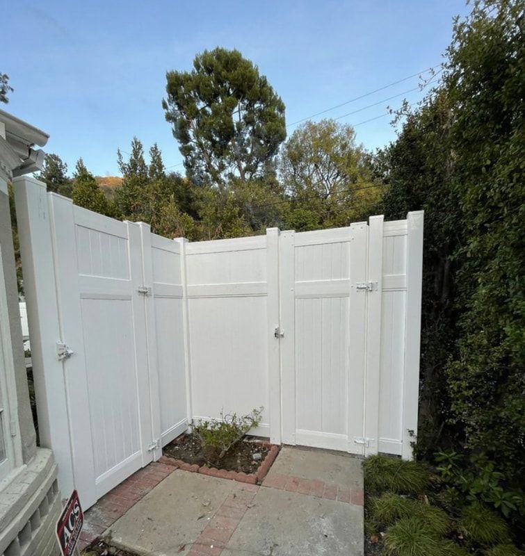 A white fence with a gate in the backyard
