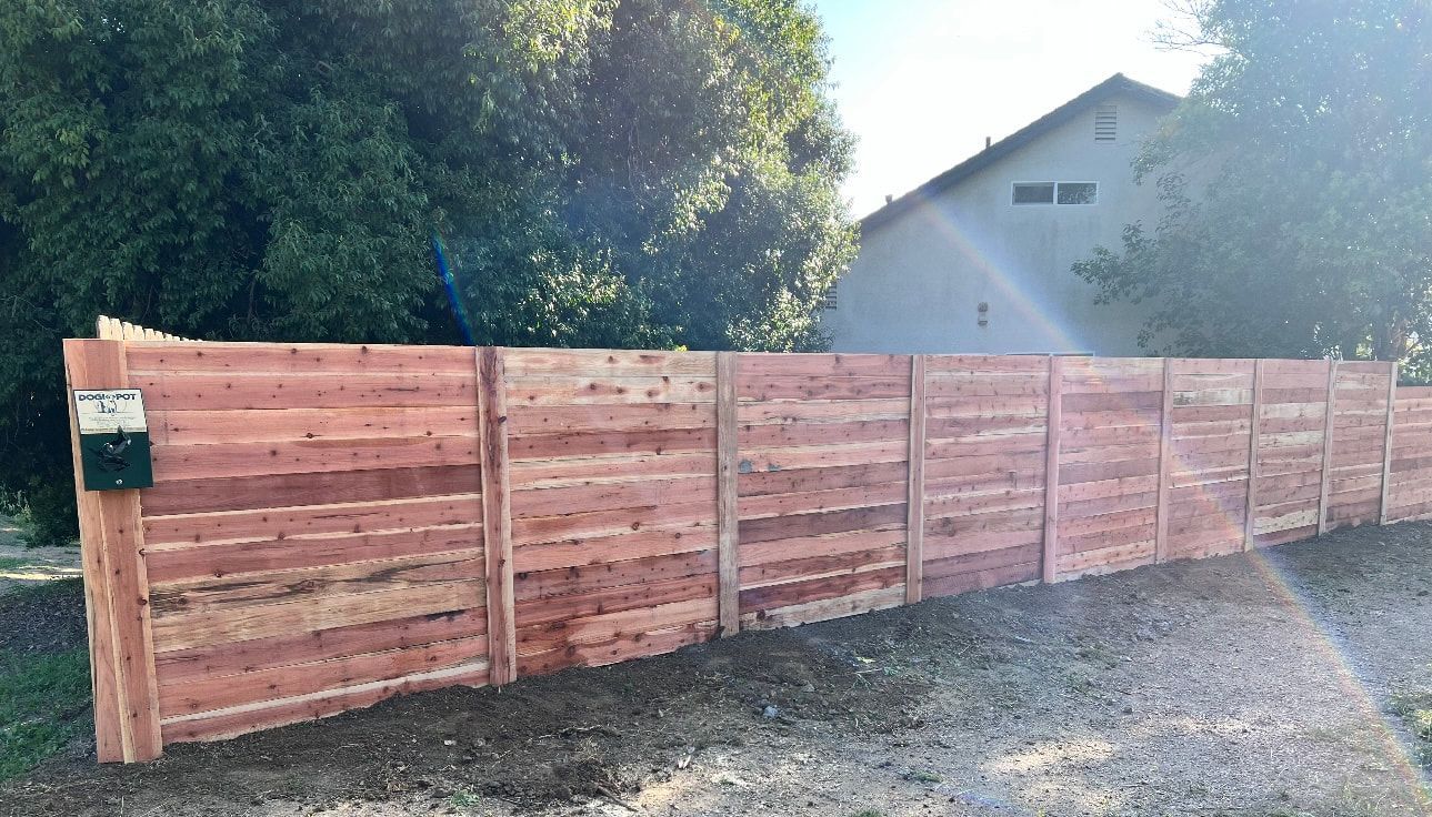 A wooden fence is sitting in front of a house.