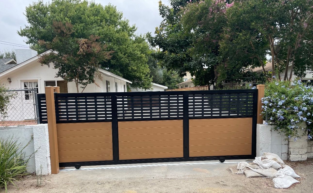 A house with a fence and a gate in front of it.