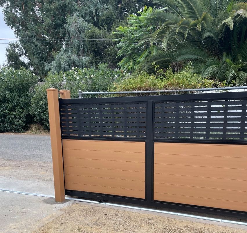 A brown and black fence with trees in the background