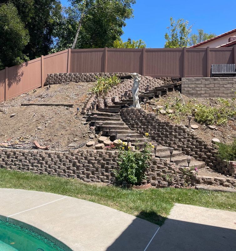 A fenced in yard with stairs leading up to a house