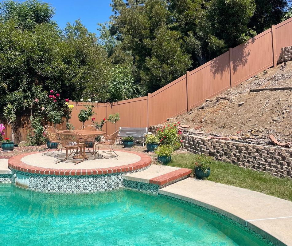 A swimming pool with a wooden fence surrounding it