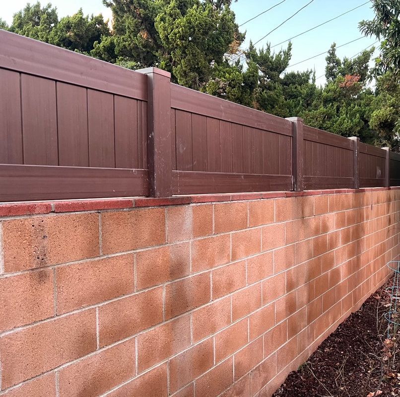 A brick wall with a wooden fence on top of it