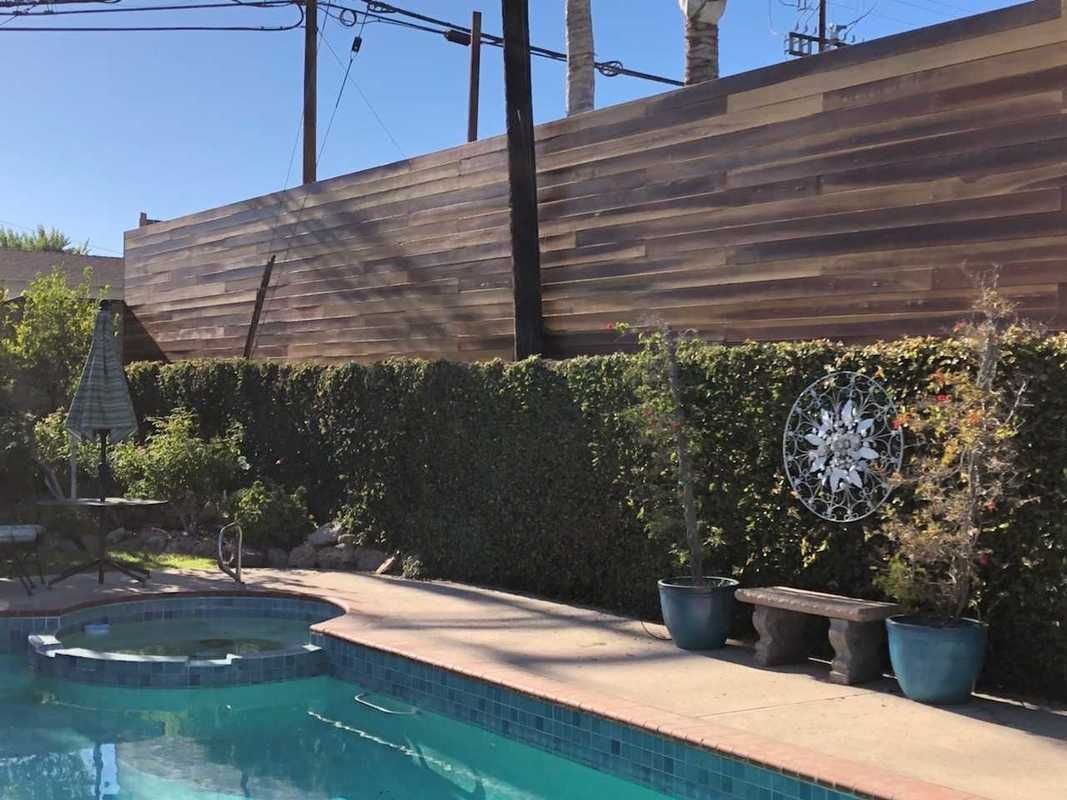A swimming pool with a wooden fence surrounding it