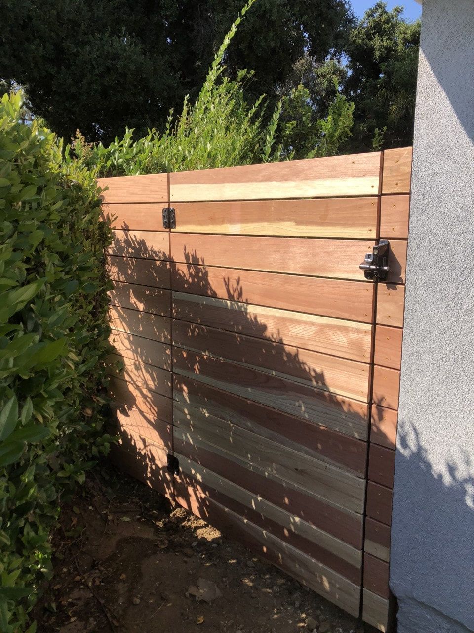 A wooden fence is surrounded by trees and bushes