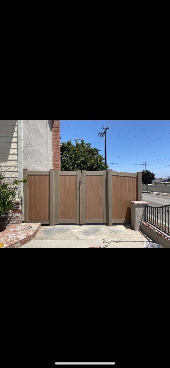 A wooden gate is sitting in front of a house.