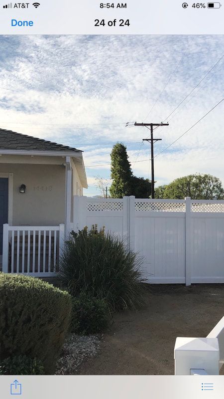 A phone screen shows a picture of a house with a white fence