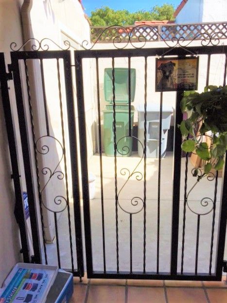 A wrought iron gate with a sign on it that says 