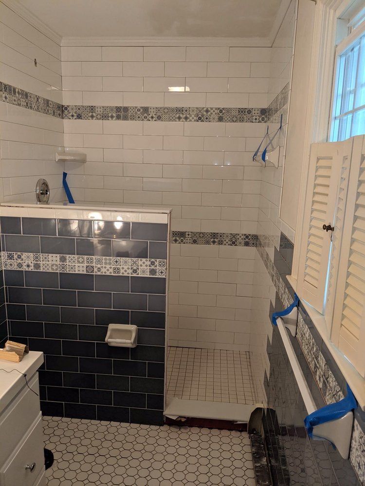 A bathroom with blue and white tiles and a walk in shower