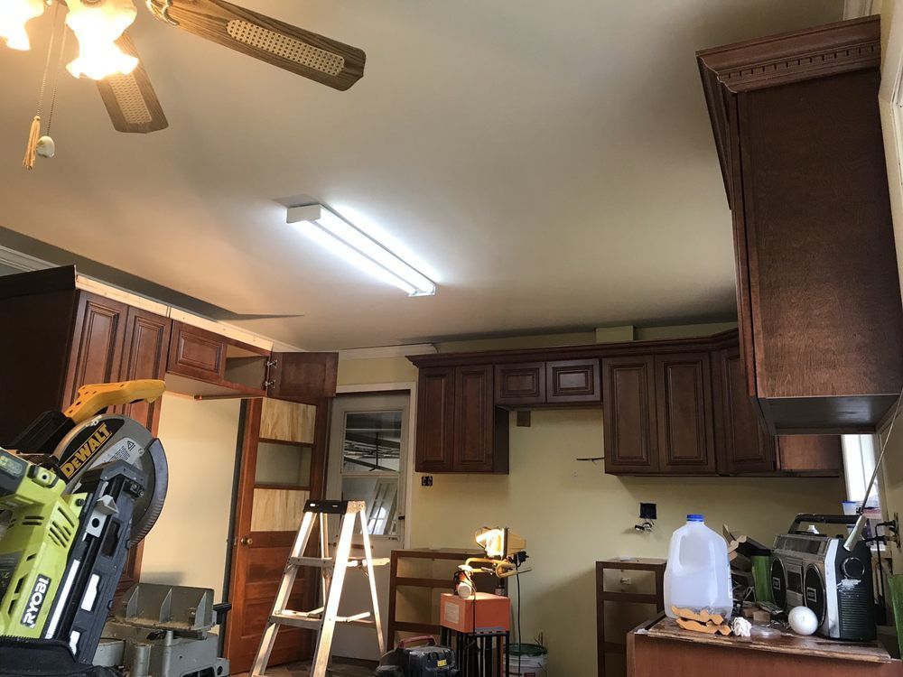A kitchen with wooden cabinets and a ceiling fan.