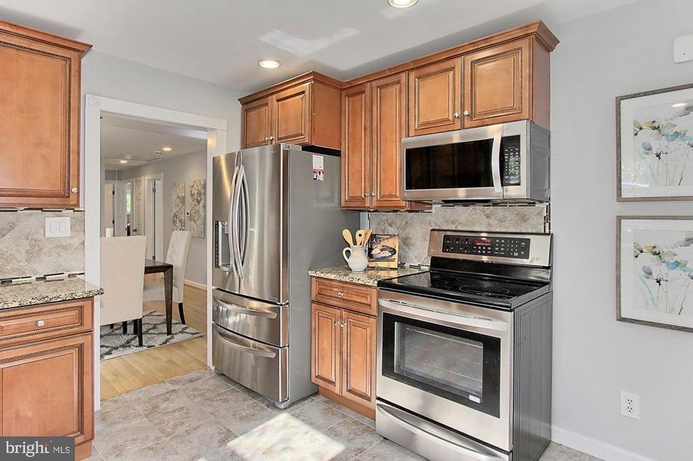 A kitchen with stainless steel appliances and wooden cabinets.