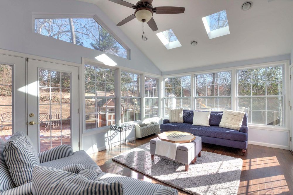 A living room with a purple couch and a ceiling fan.