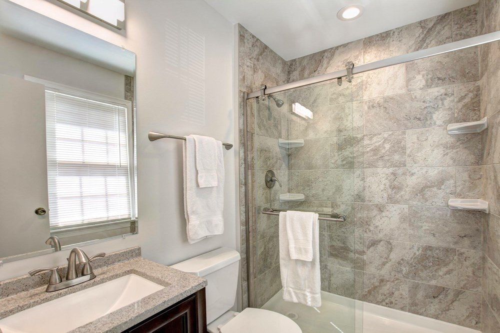 A bathroom with a toilet , sink , and shower.