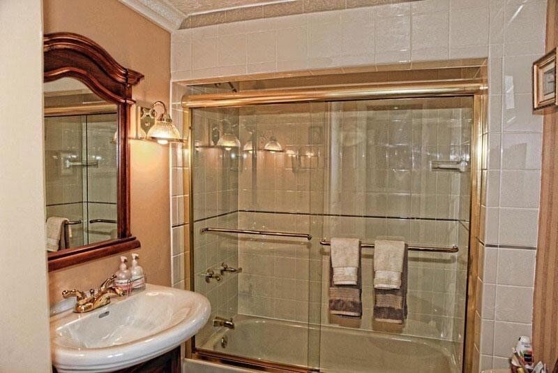 A bathroom with a sink , mirror , tub and shower.