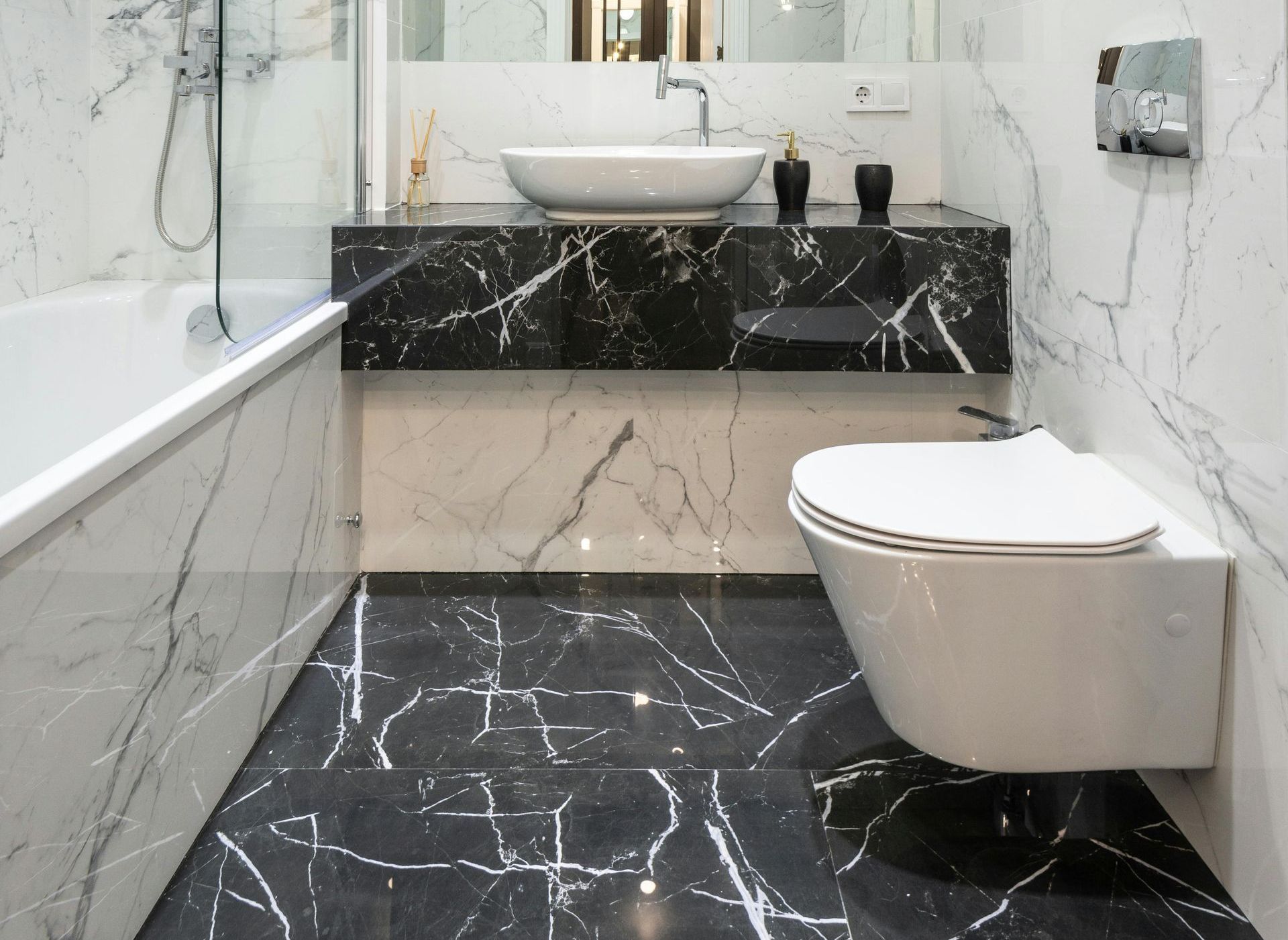 A bathroom with a claw foot tub , toilet , sink and mirror.