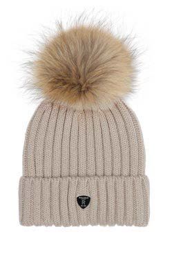 Beige gerippte Strickmütze mit hellbraunem Kunstfellbommel und schwarzem Logo auf dem umgeschlagenen Rand.