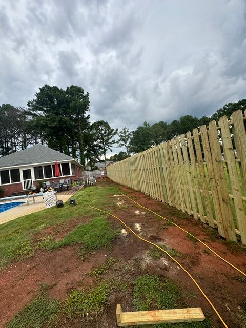 A wooden fence is being built in front of a house.