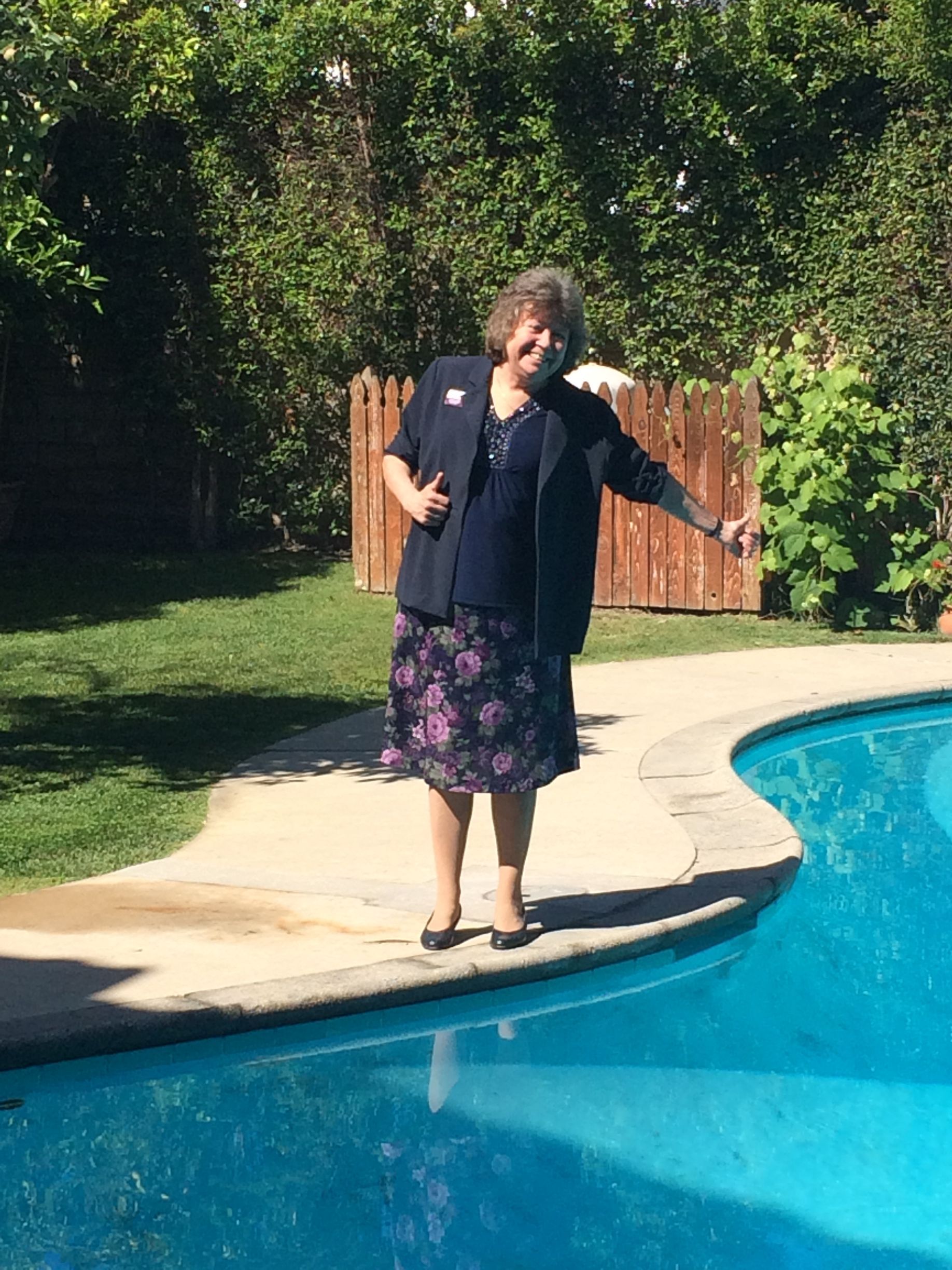 A living room with a couch , chairs , ottoman and a mirror