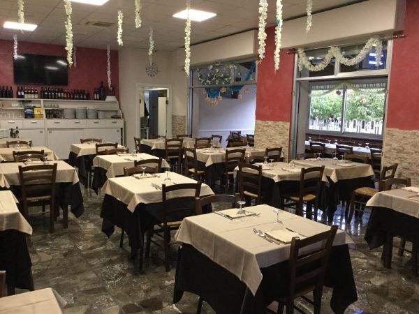Tavoli imbanditi all'interno della trattoria