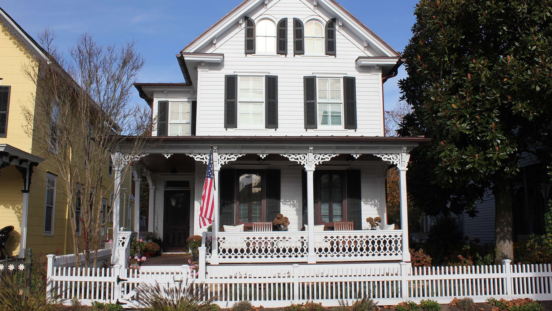 A large white house with black shutters and a porch in cape may, new jersey