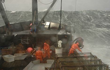 A group of people are working on a boat in the ocean.