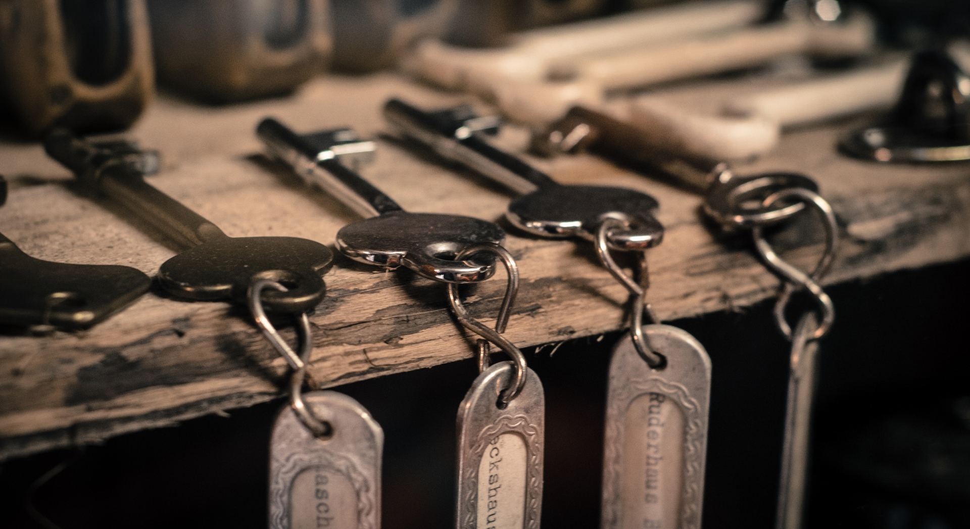 A bunch of keys hanging on a wooden table.