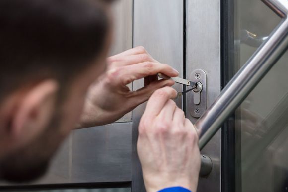 A man is using a screwdriver to open a door.