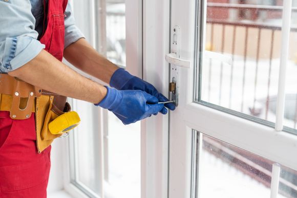 A man is fixing a door with a screwdriver.