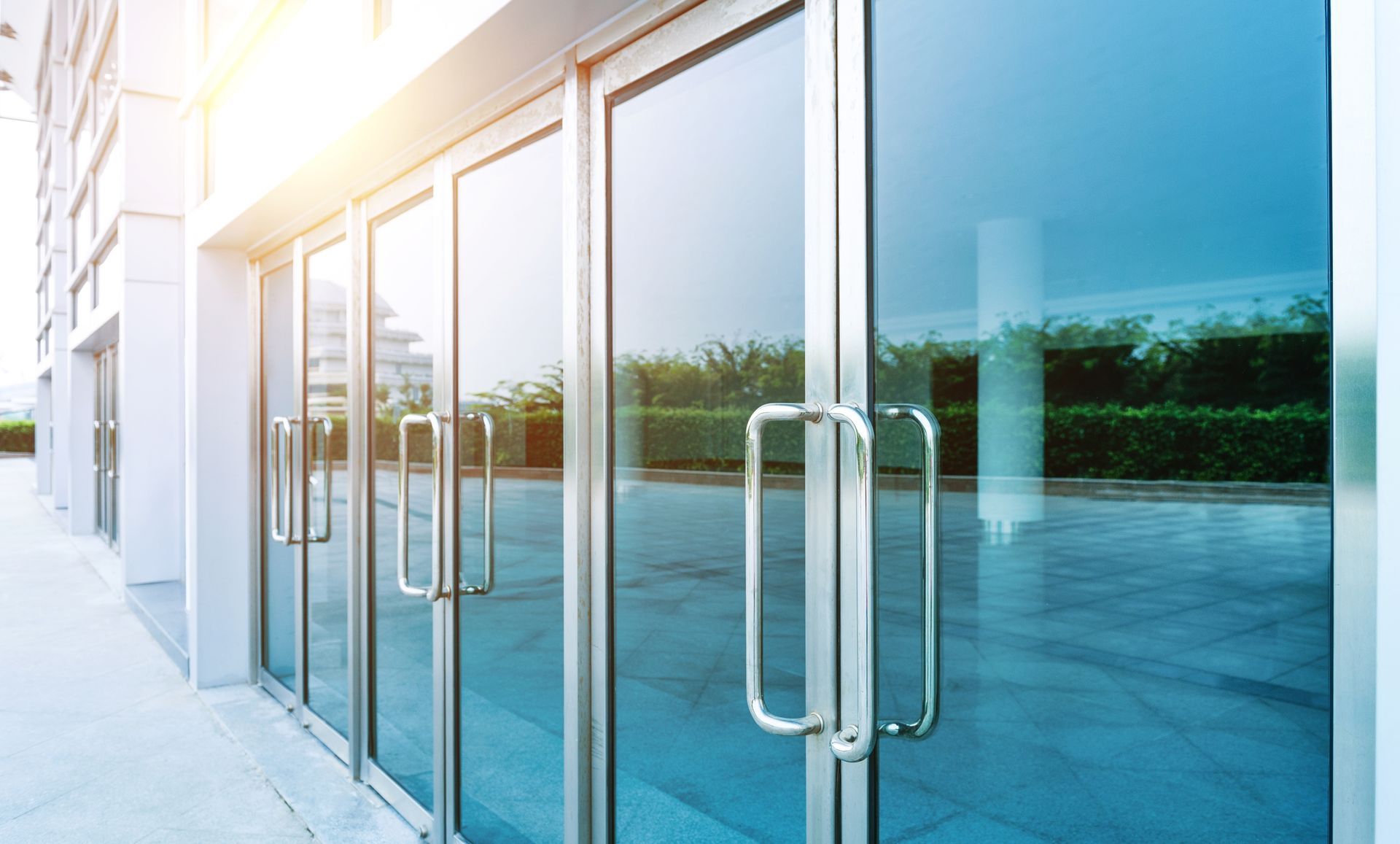 The sun is shining through the glass doors of a building.