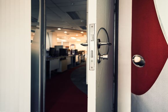 A door is open to an office with a red carpet