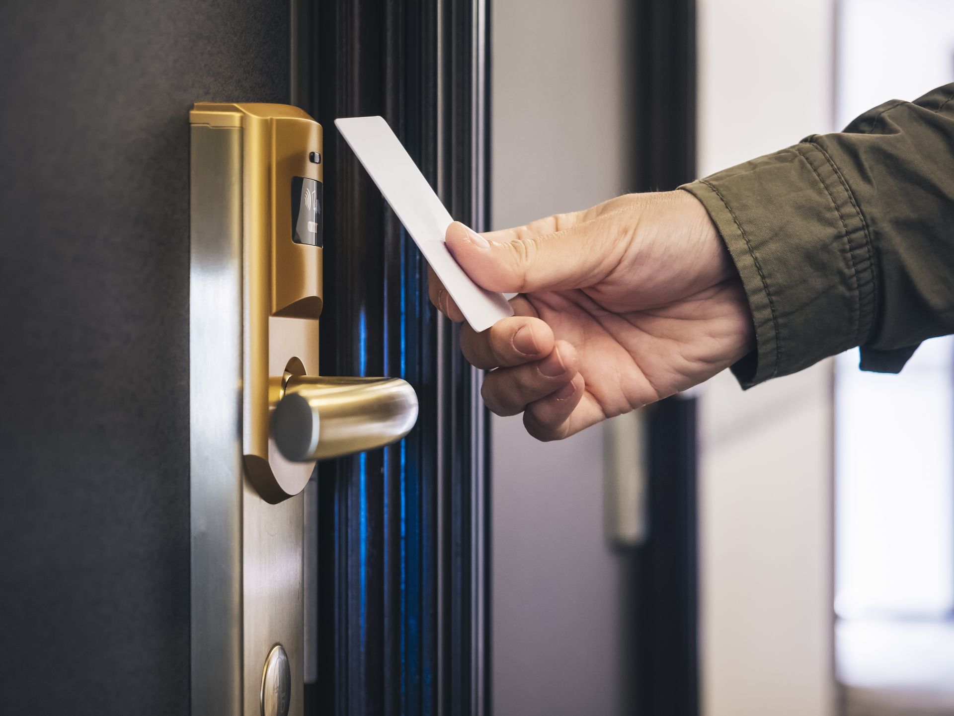 A person is using a credit card to open a hotel door.