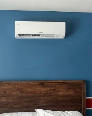 A bedroom with a blue wall and a bed with a wooden headboard.