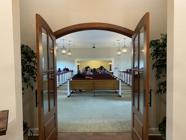 A church with the doors open and people sitting in the pews