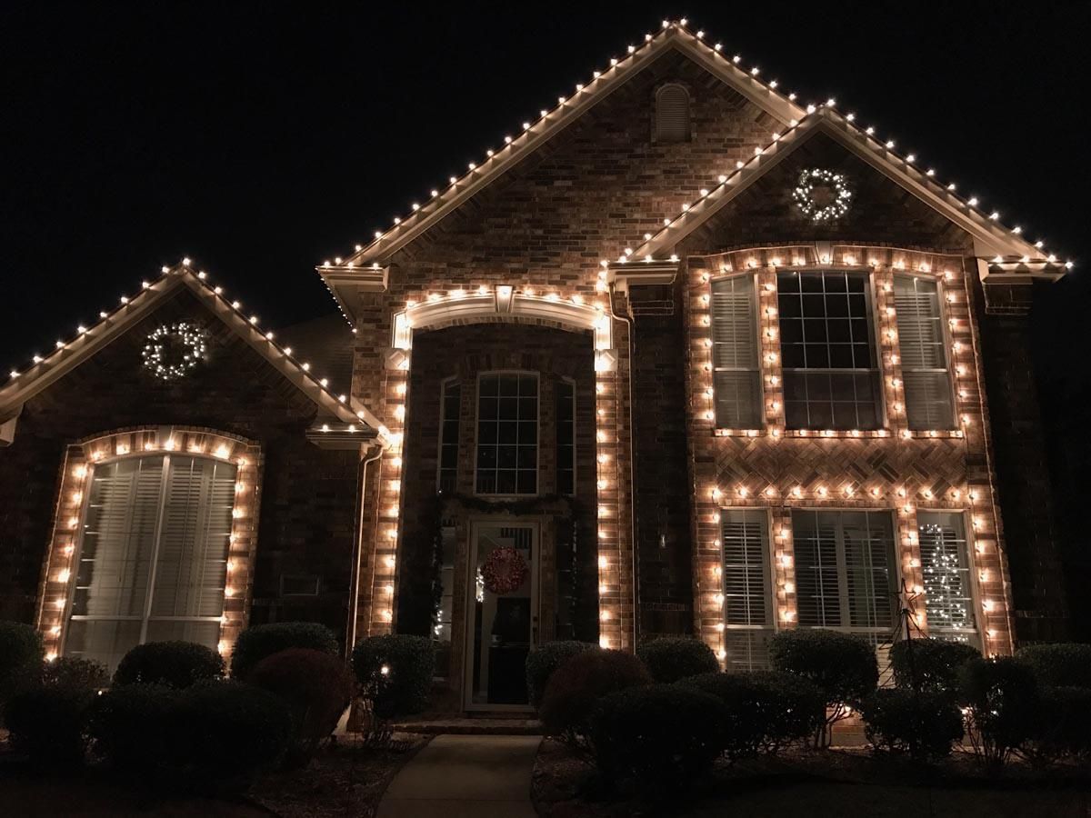 House decorated with white Christmas lights for the holidays.