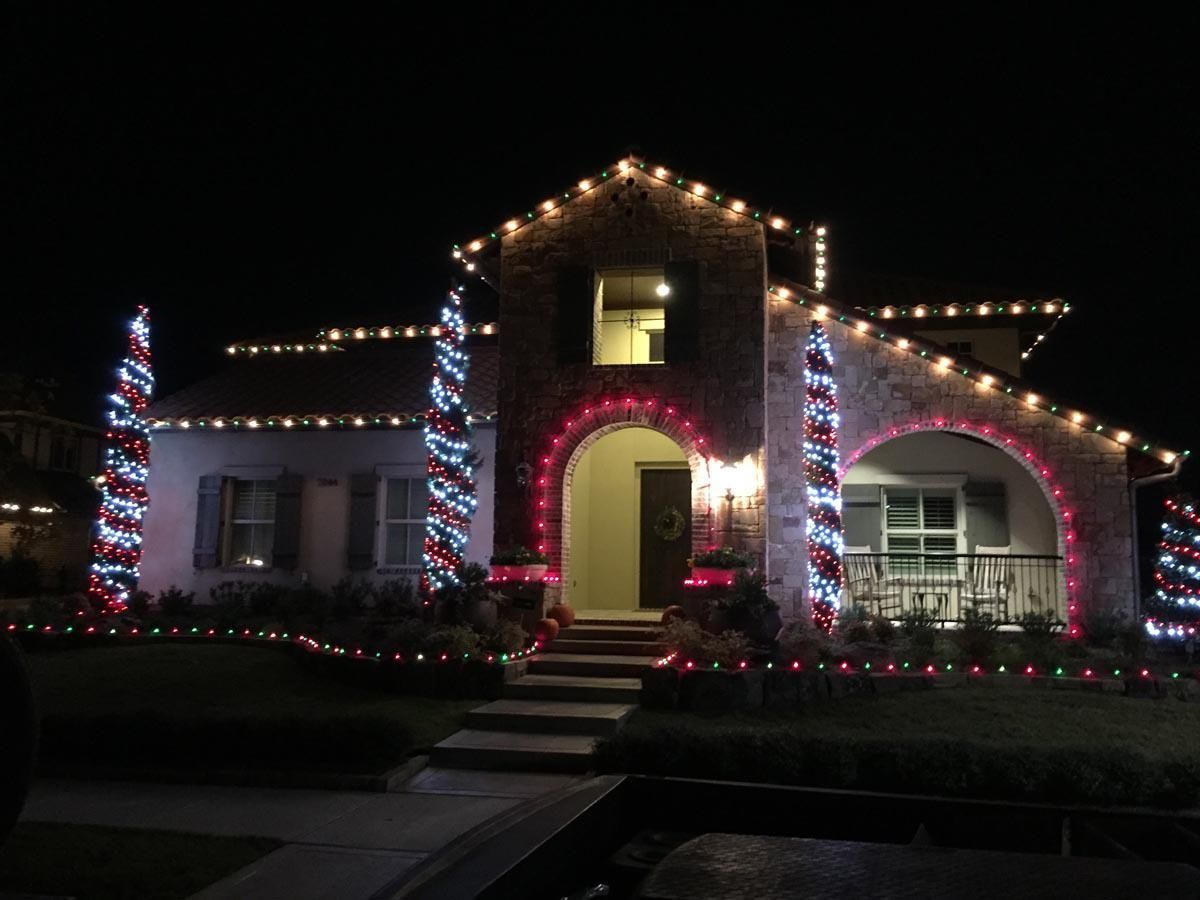 House at night decorated with red, white, and blue Christmas lights.