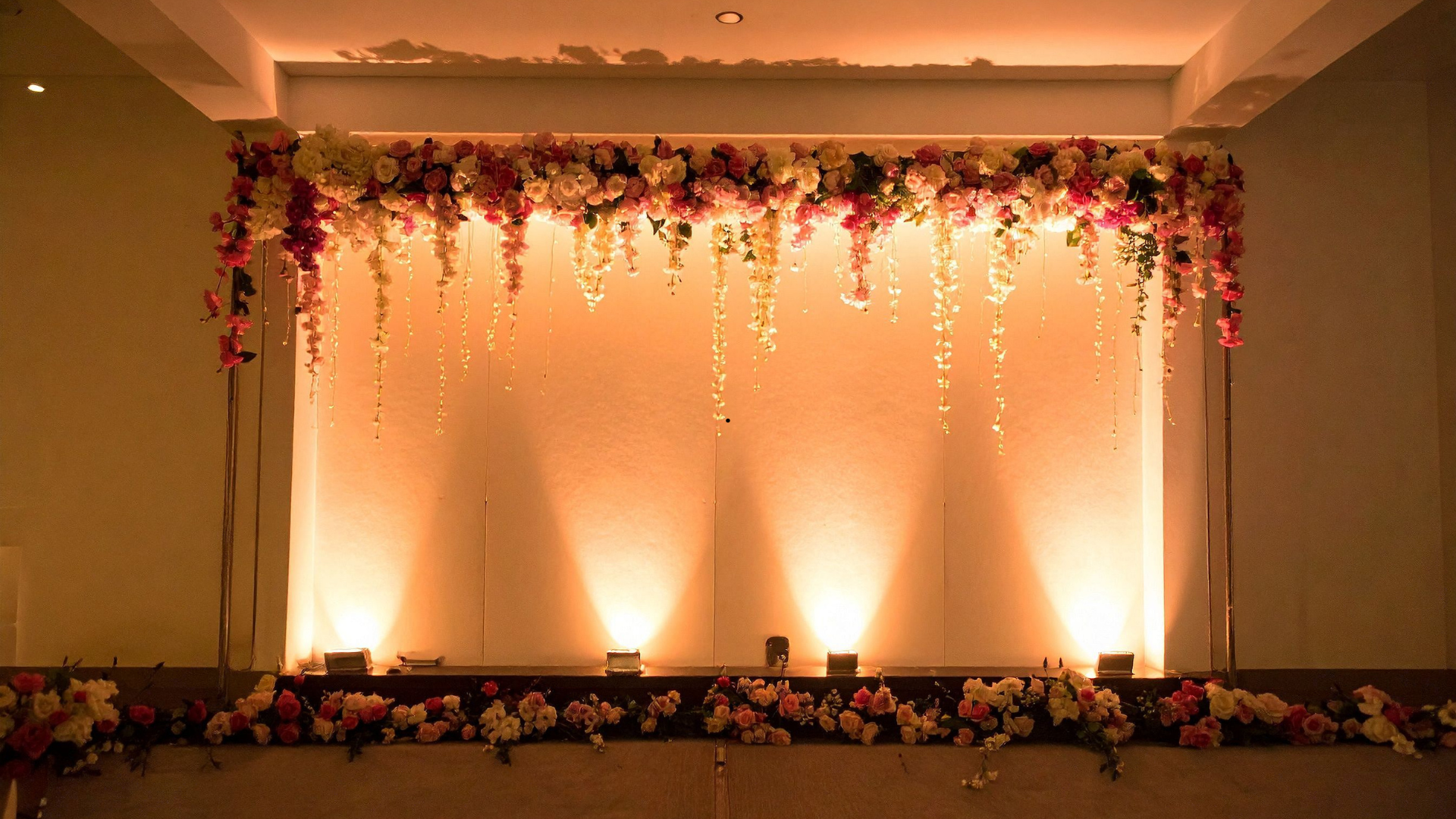 Stage with floral decorations and warm lighting.