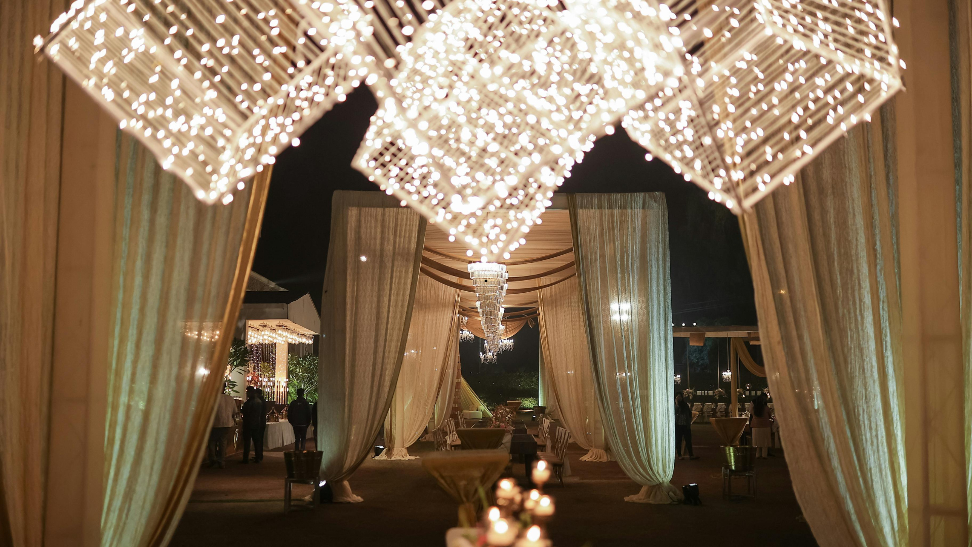 Entrance to an event with draped fabric and hanging lights.