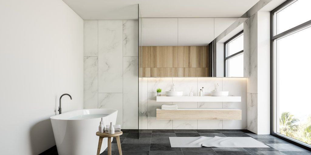 A bathroom with a bathtub , sinks , and a large window.