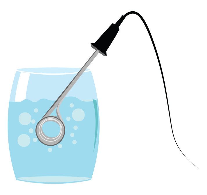 A thermometer is sticking out of a glass of water.