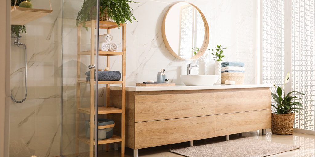A bathroom with a sink , mirror , and shower stall.