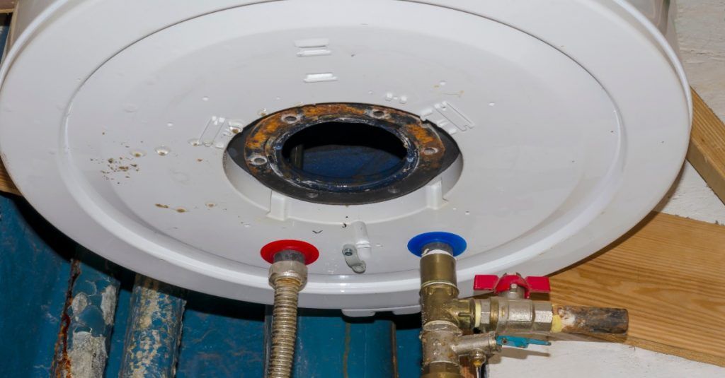 A close up of a water heater with two valves attached to it.