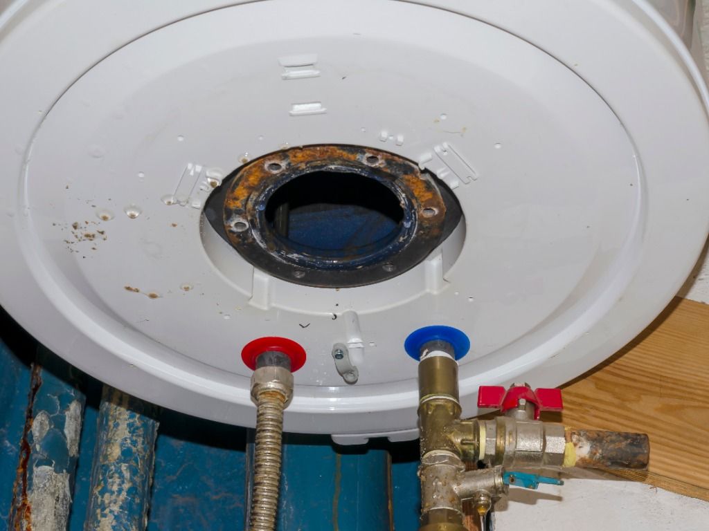 A close up of a water heater with a hose attached to it