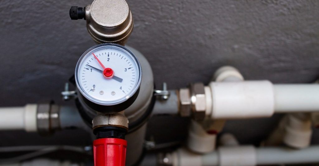 A close up of a pressure gauge on a pipe.