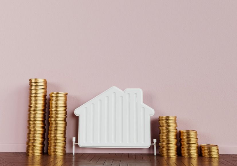 A stack of gold coins next to a model of a house.