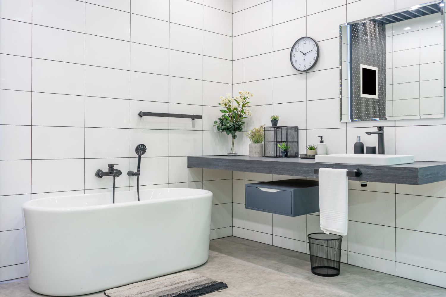 A bathroom with a bathtub, sink, mirror and clock. A bathroom with a bathtub, sink, mirror and clock.
