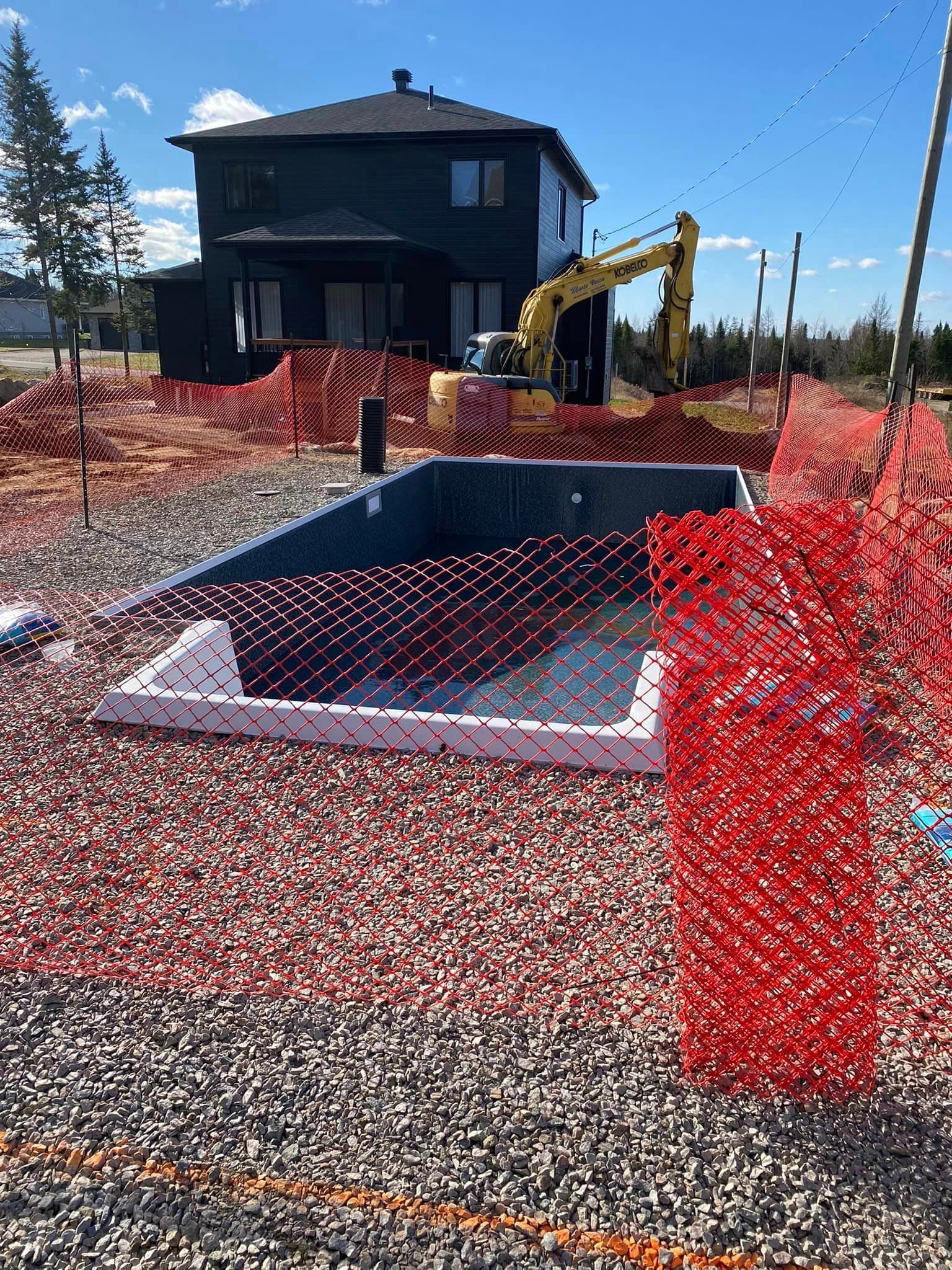 Une grande maison est en construction à côté d'une grande piscine.