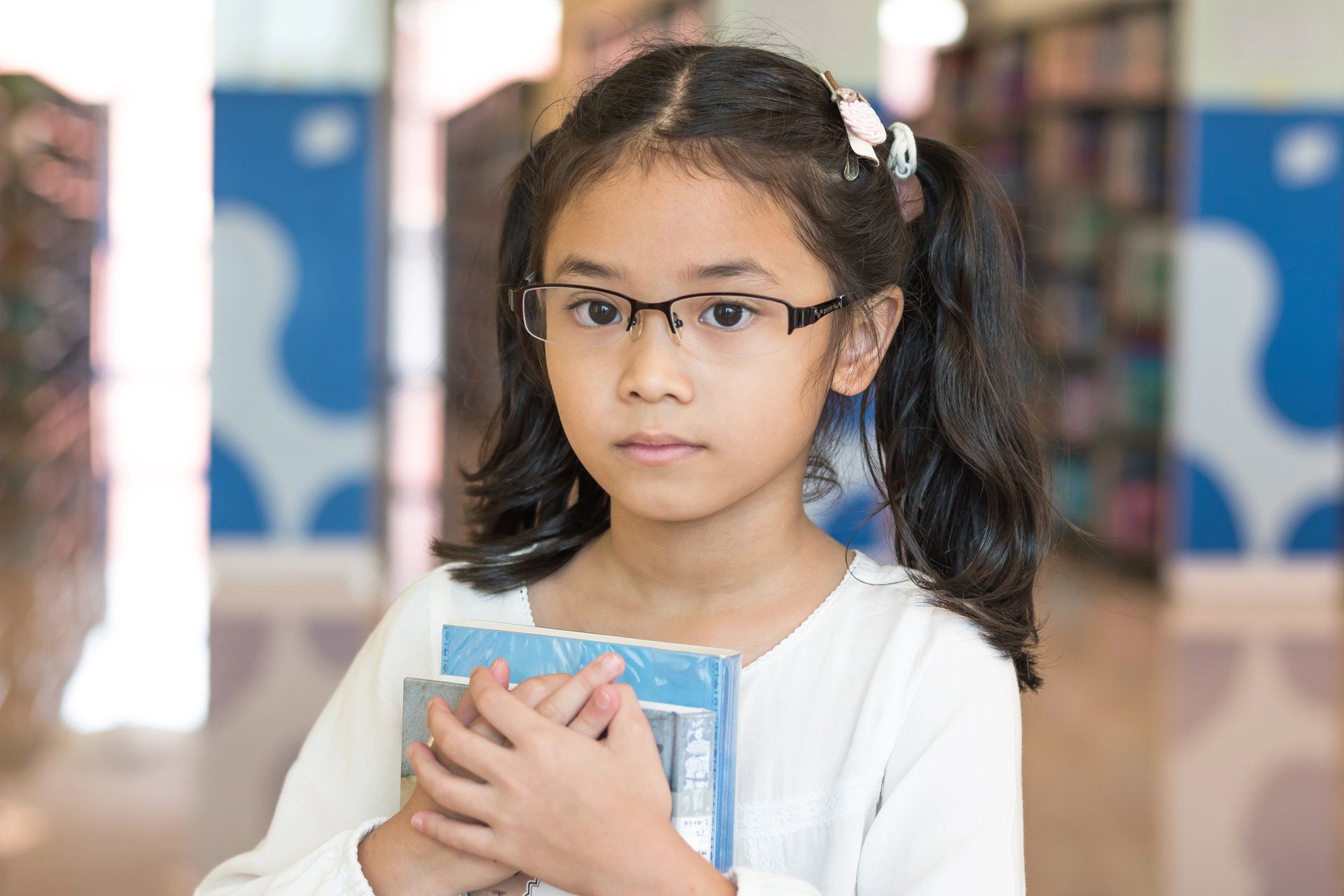 little girl holding books in the library