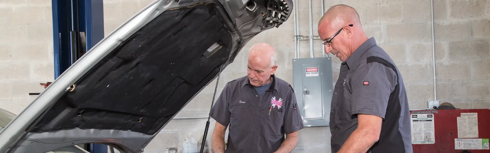 Two technicians looking under hood of car | Englewood Tire Services at Xpertech Auto Repair, Inc.